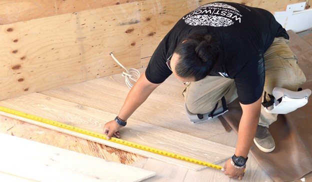 Why-In-House-Install-1 Why-In-House-Install-worker-measuring-floor-plank